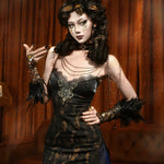Woman in a dark, ornate dress with feathered accessories against a brown curtain background