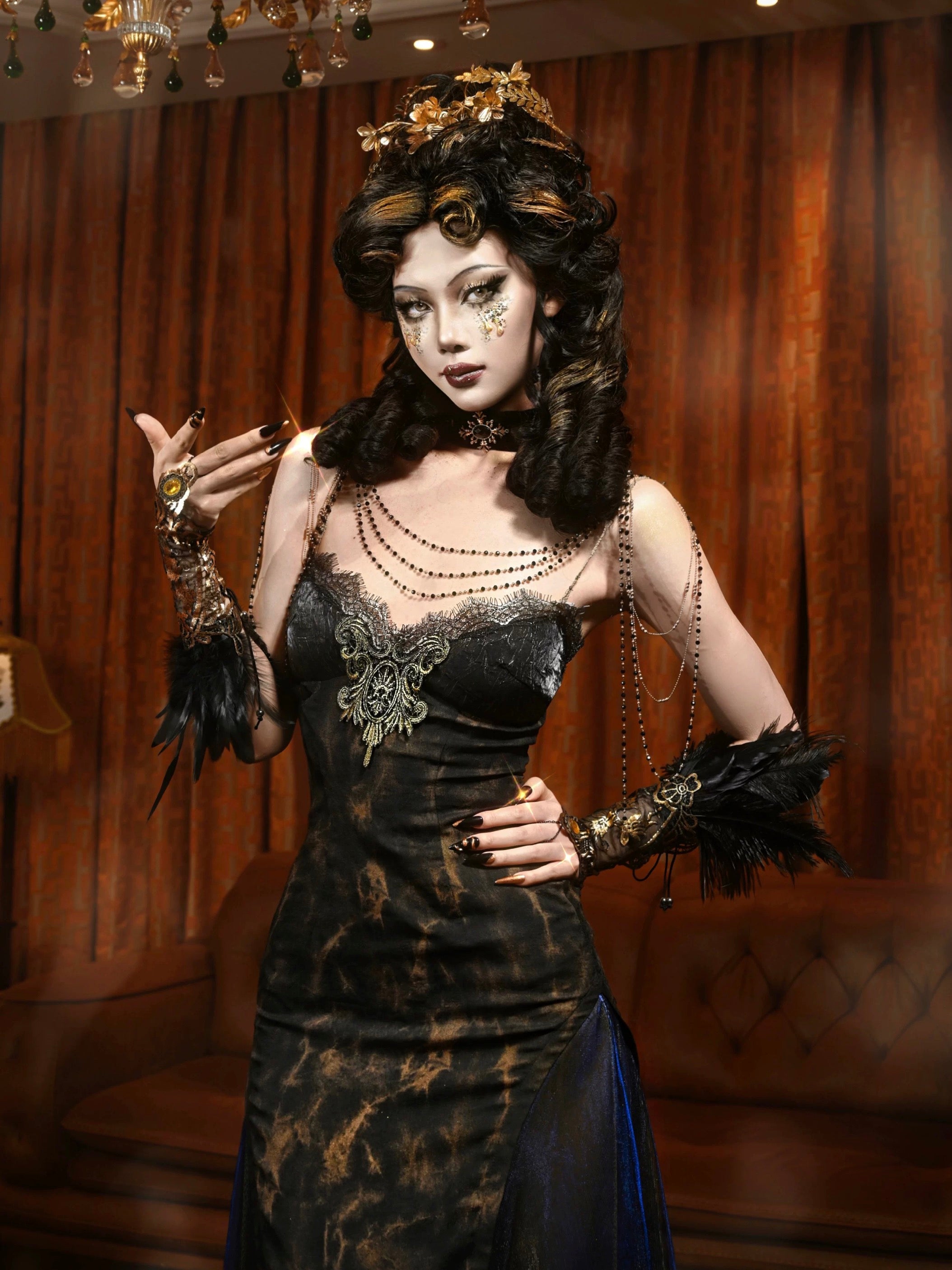 Woman in a dark, ornate dress with feathered accessories against a brown curtain background