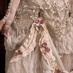 Close-up of a decorative garment with lace and ribbons