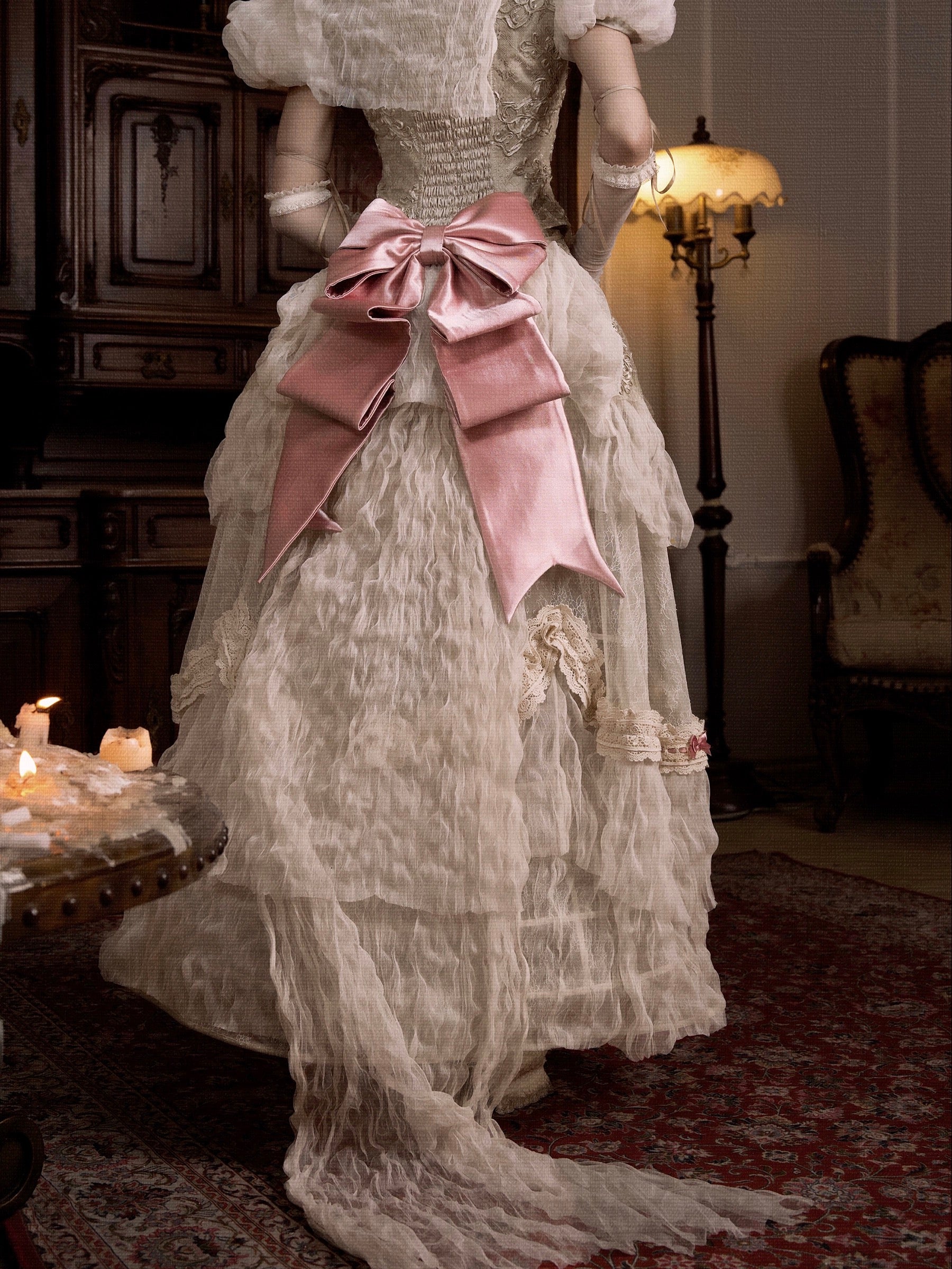 Vintage-style dress with a large pink bow in an elegant room setting.
