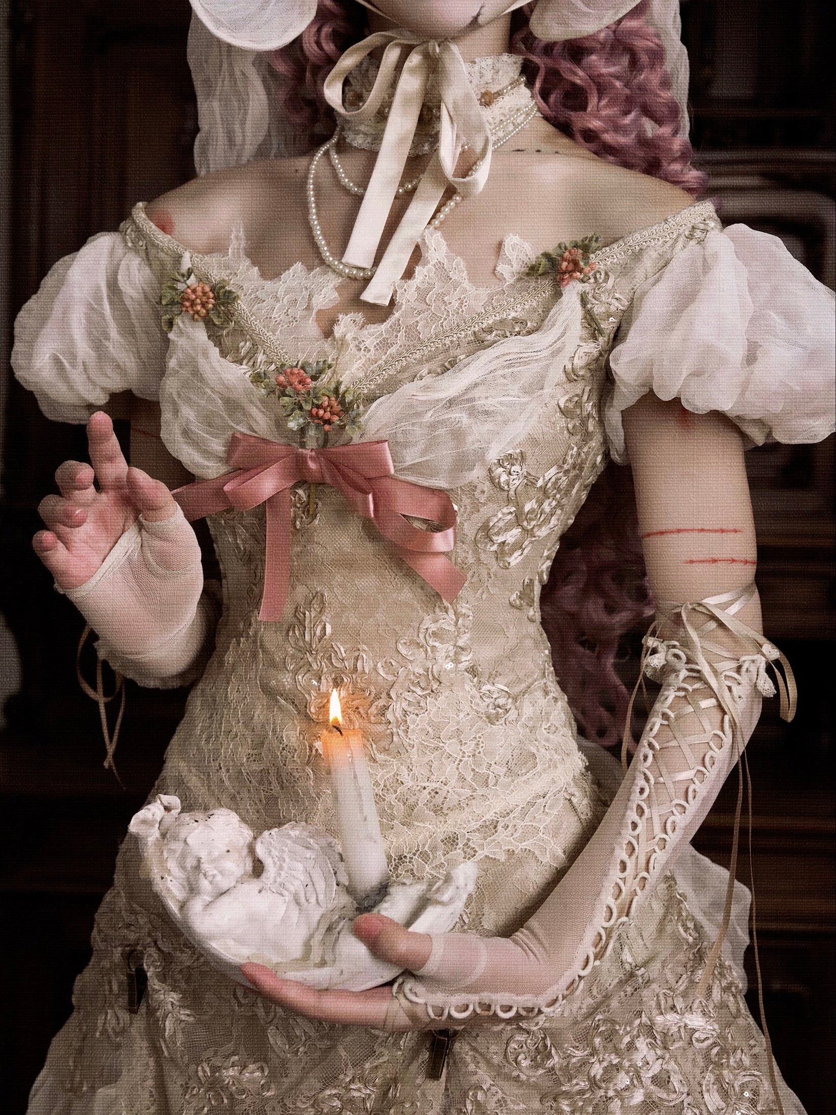 girl in an vintage floral bridal dress holding a candle, with a dark background. Gothic fashion for halloween wear.