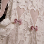 Lace fabric with heart cutouts and pink bows