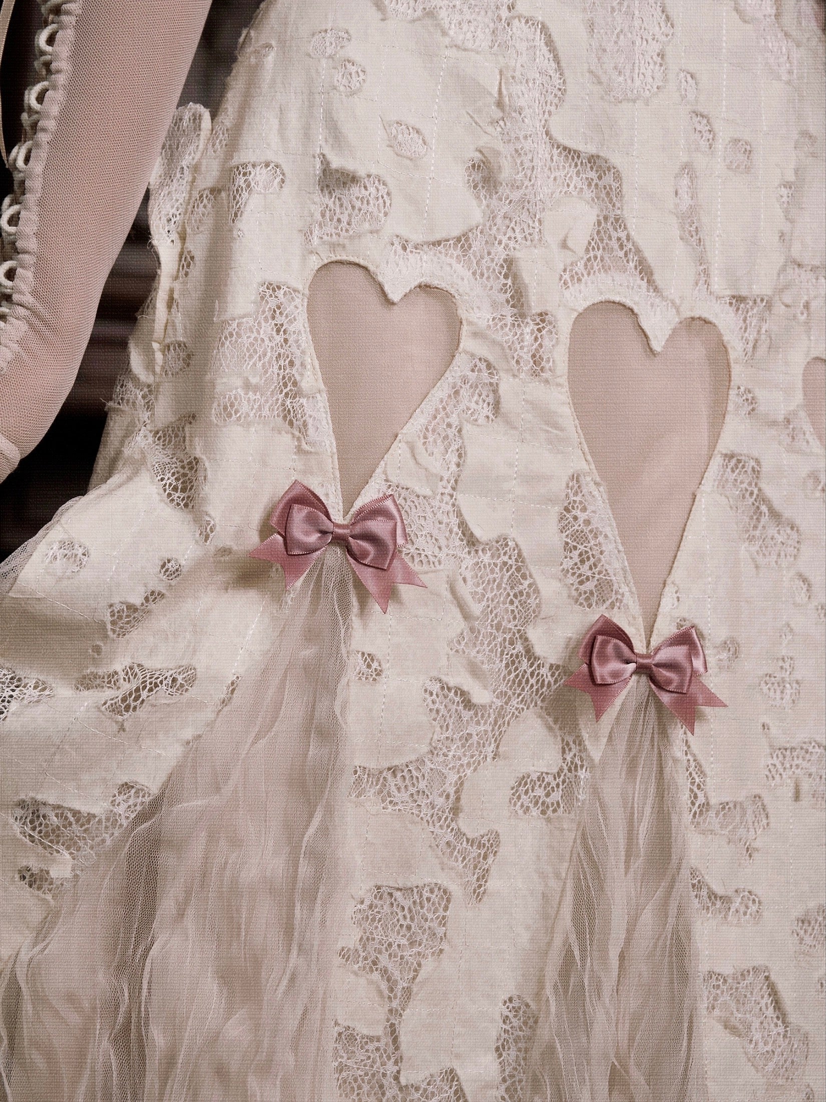 Lace fabric with heart cutouts and pink bows