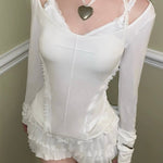Girl wearing a white lace gothic crop top outfit with a heart-shaped pendant with KittenClaw White Dream Cross Set