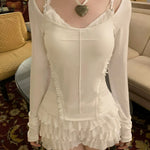 Person wearing a white lace top and skirt KittenClaw White Dream Cross Set in a vintage hotel room