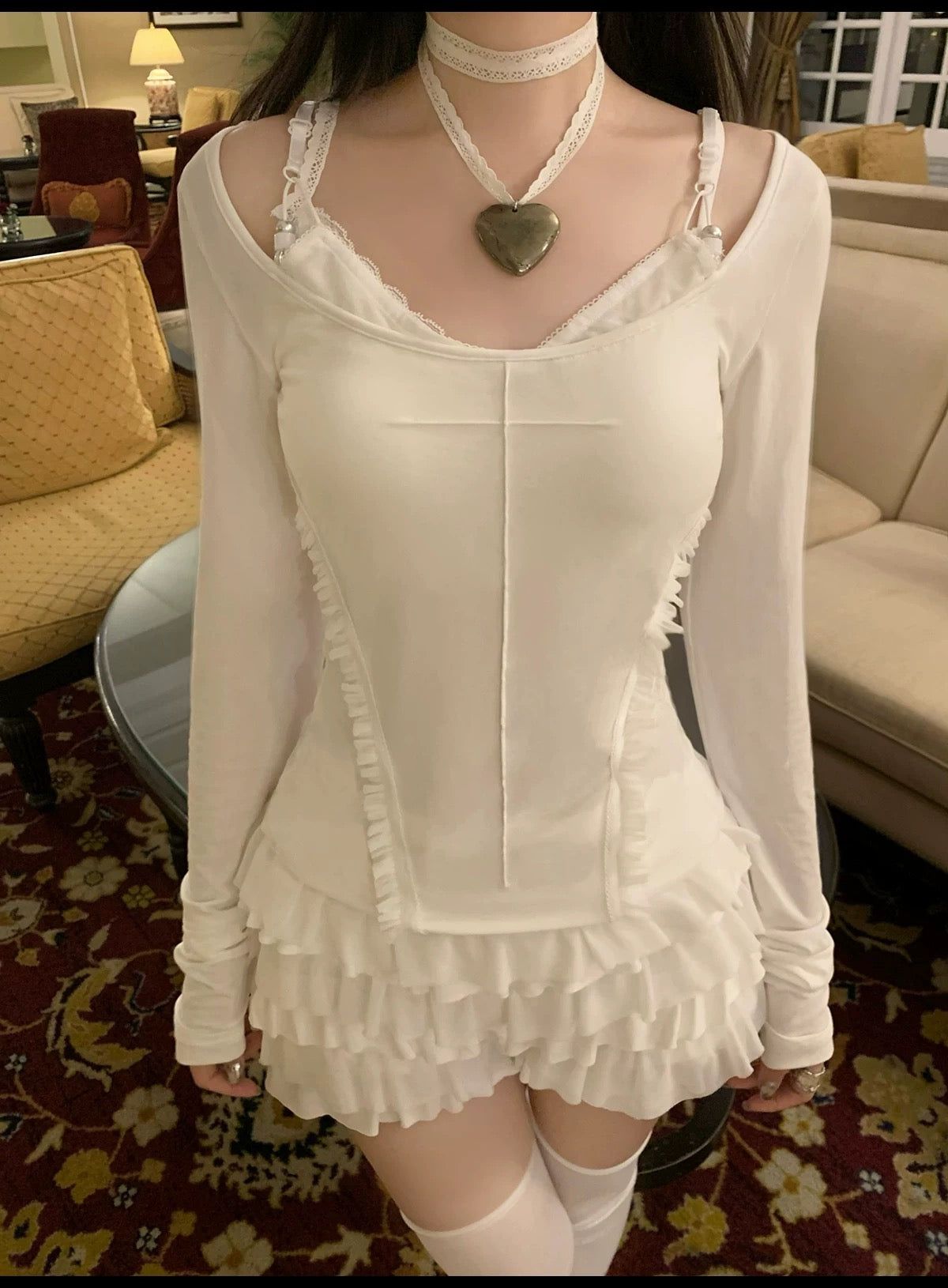 Person wearing a white lace top and skirt KittenClaw White Dream Cross Set in a vintage hotel room