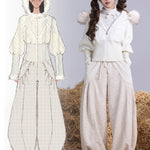 White winter outfit with fur trim on a person standing on hay. with design hand drawing picture on the side