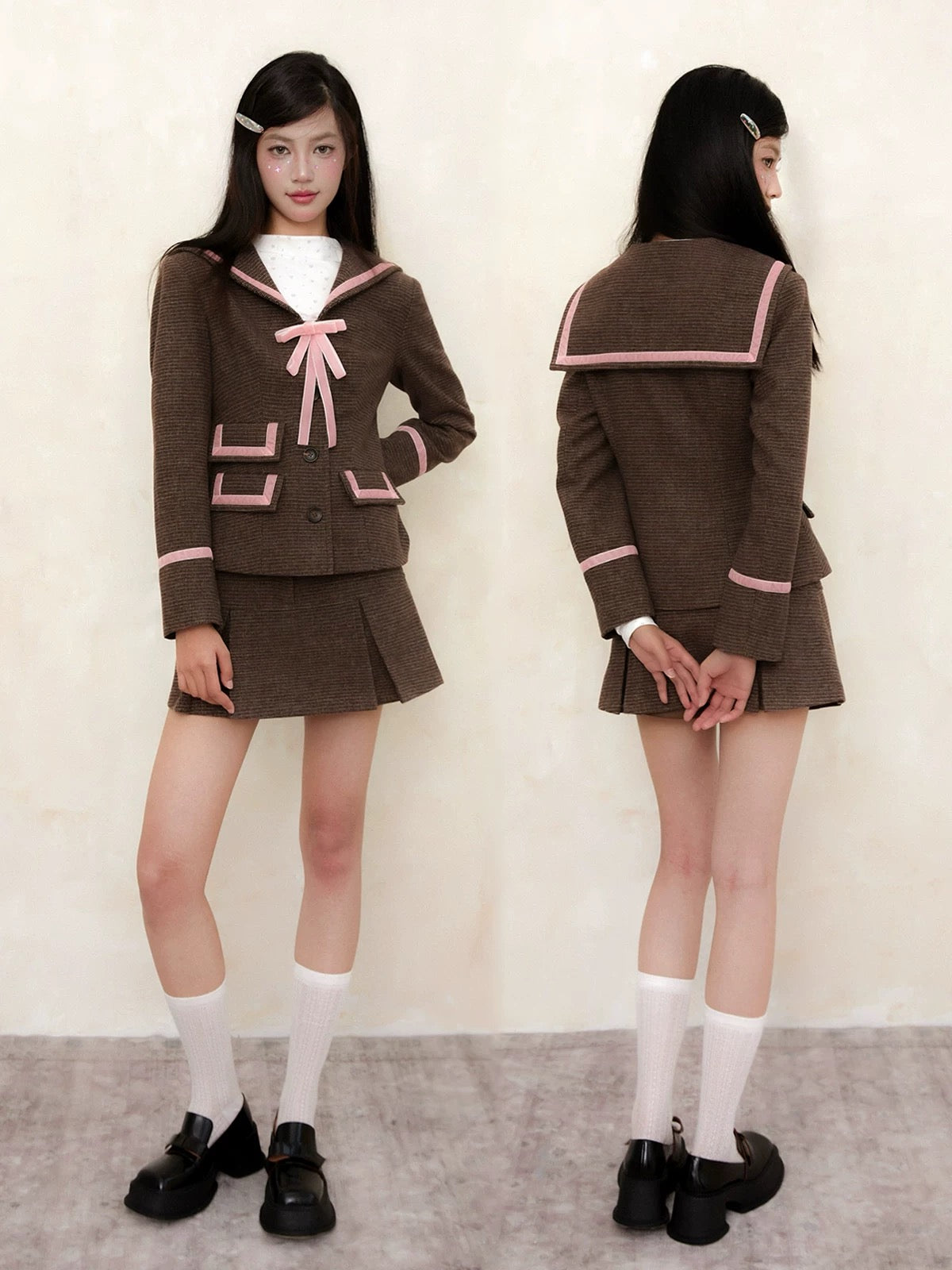 School girl wearing a brown school uniform with pink accents, standing against a plain background.