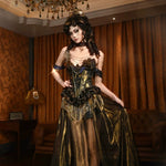 Woman in a gold and black dress standing in an opulent room with chandelier and curtains.