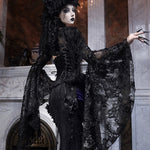 Person in a dark, ornate costume standing in an elegant gothic lace and vintage palace design.