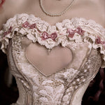 Lace corset with floral details and a pearl necklace and pink ribbons 