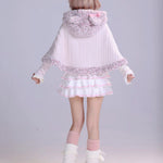 Girl wearing a white and pink fluffy faux fur cape with a matching pastel white mini skirt and leg warmmers