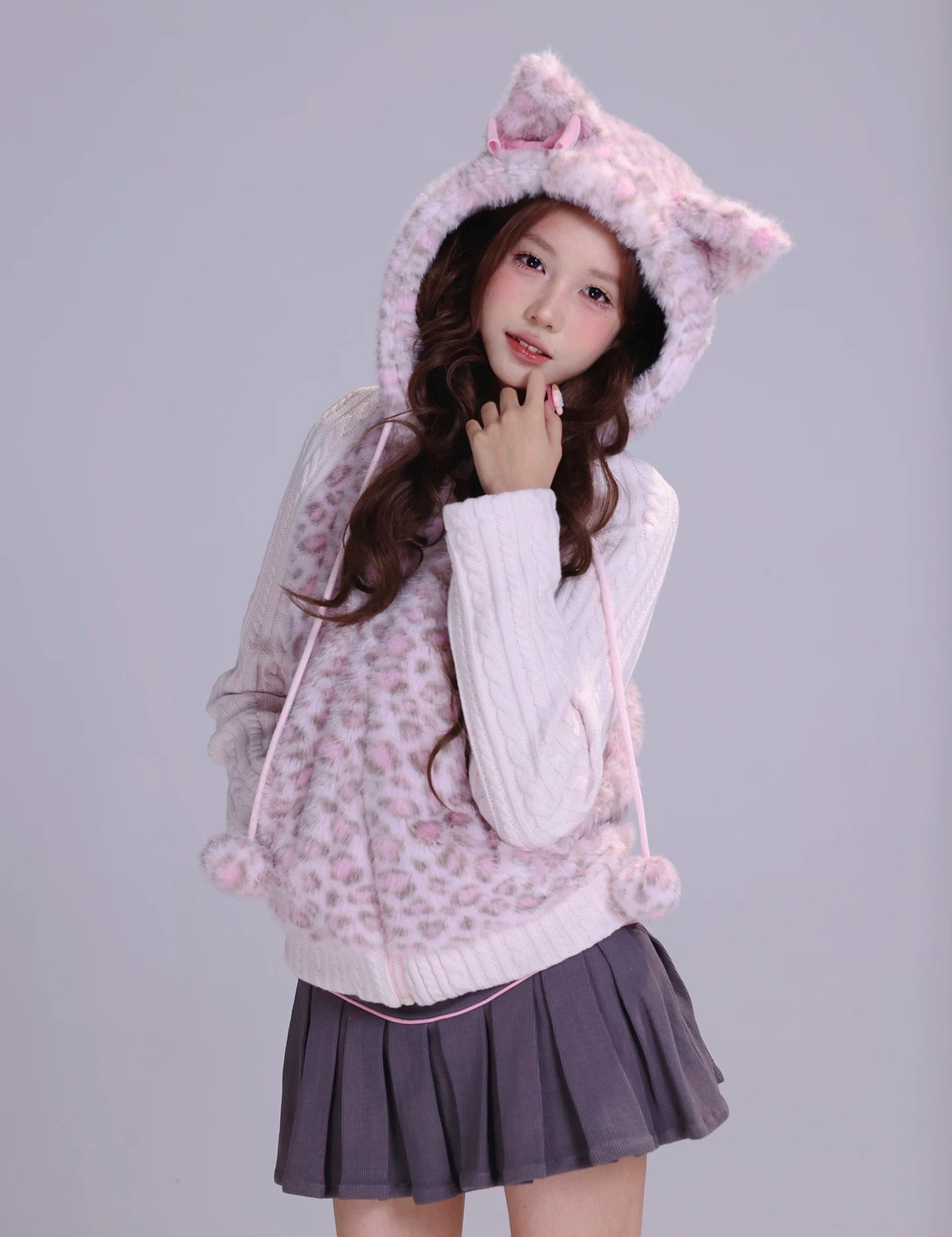 Girl wearing a pink hoodie with cat ears in fluffy faux fur fabric