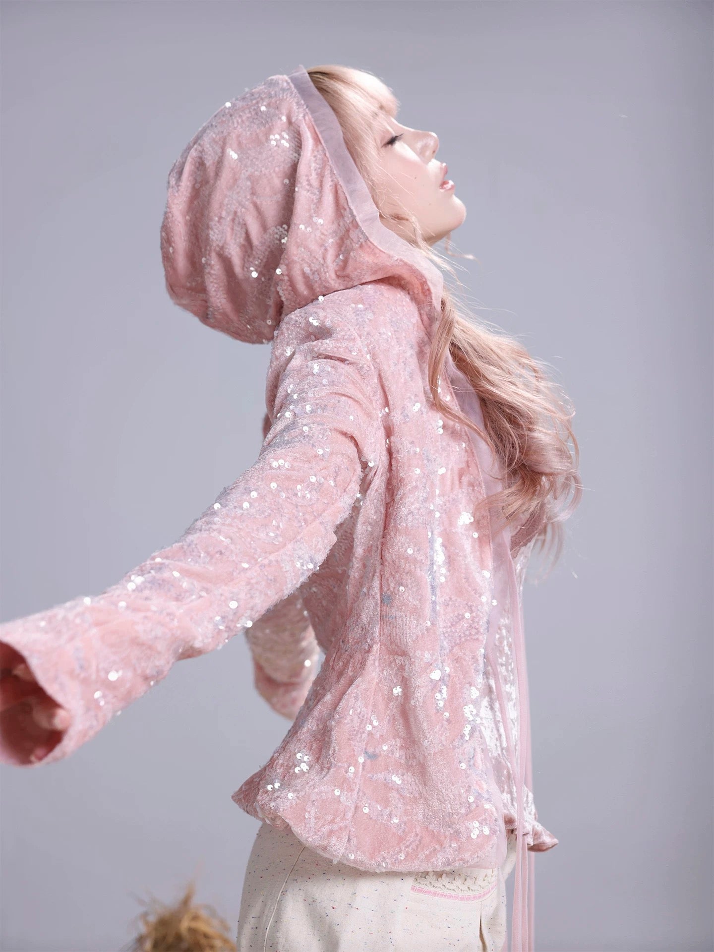 Person wearing a pink sequin hoodie inspired by skins Cassie outfits style 