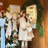 Woman in a plaid fawn deer dress standing in a decorated room with Christmas decorations.